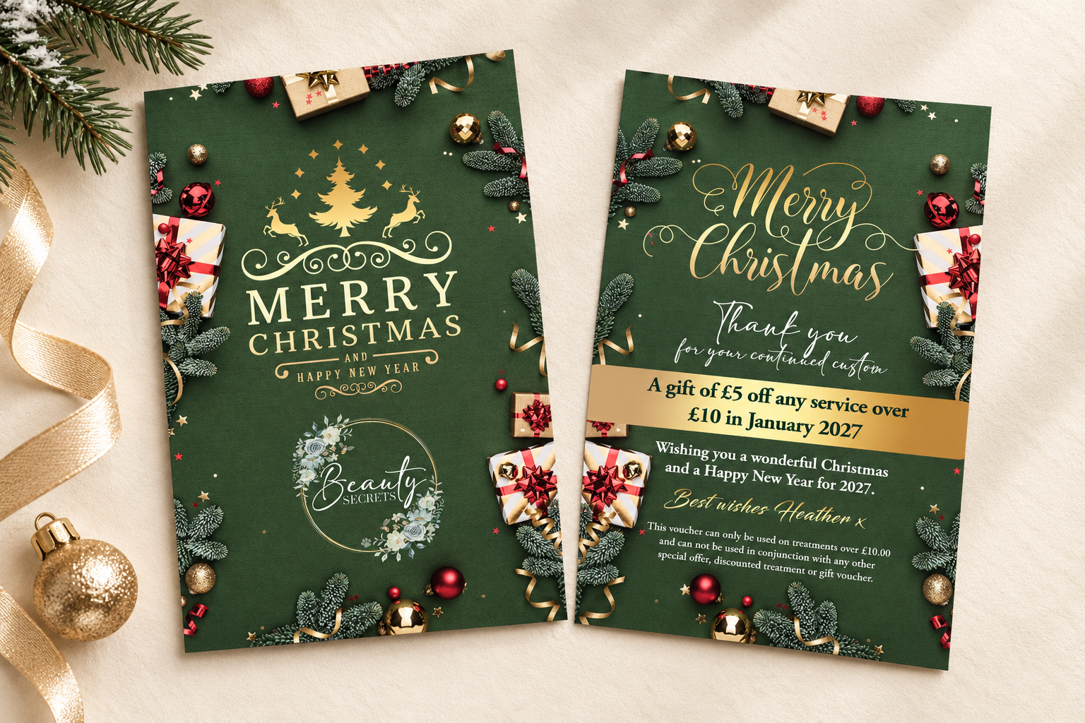 Front and reverse of branded Christmas cards displayed with subtle greenery and gold ribbon